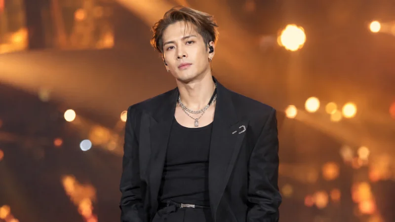 Jackson Wang standing on stage under concert lighting